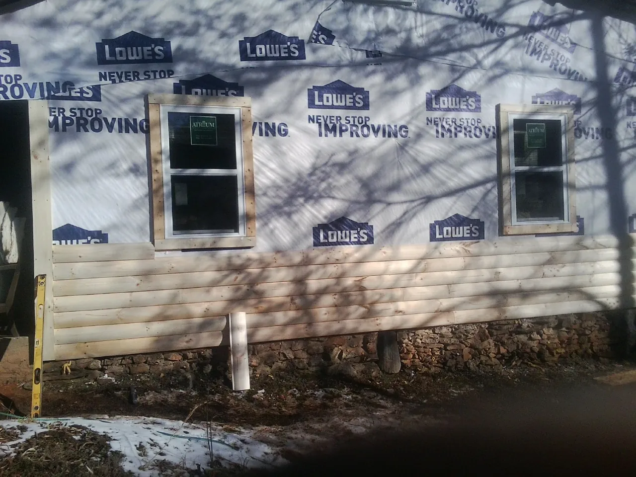 House wrap and new log siding going up on an exterior wall in Palm City