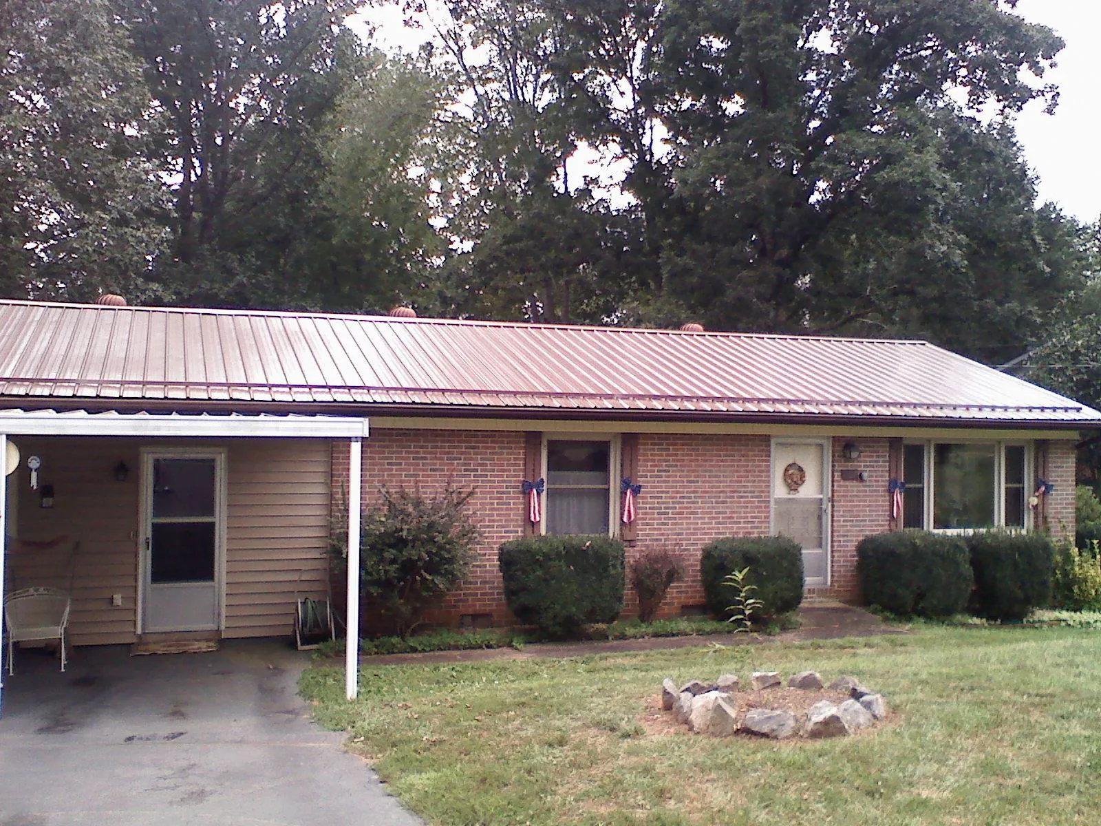 Bronze metal roof and carport on a brick ranch home — Roof Repair work by our crew in Palm City